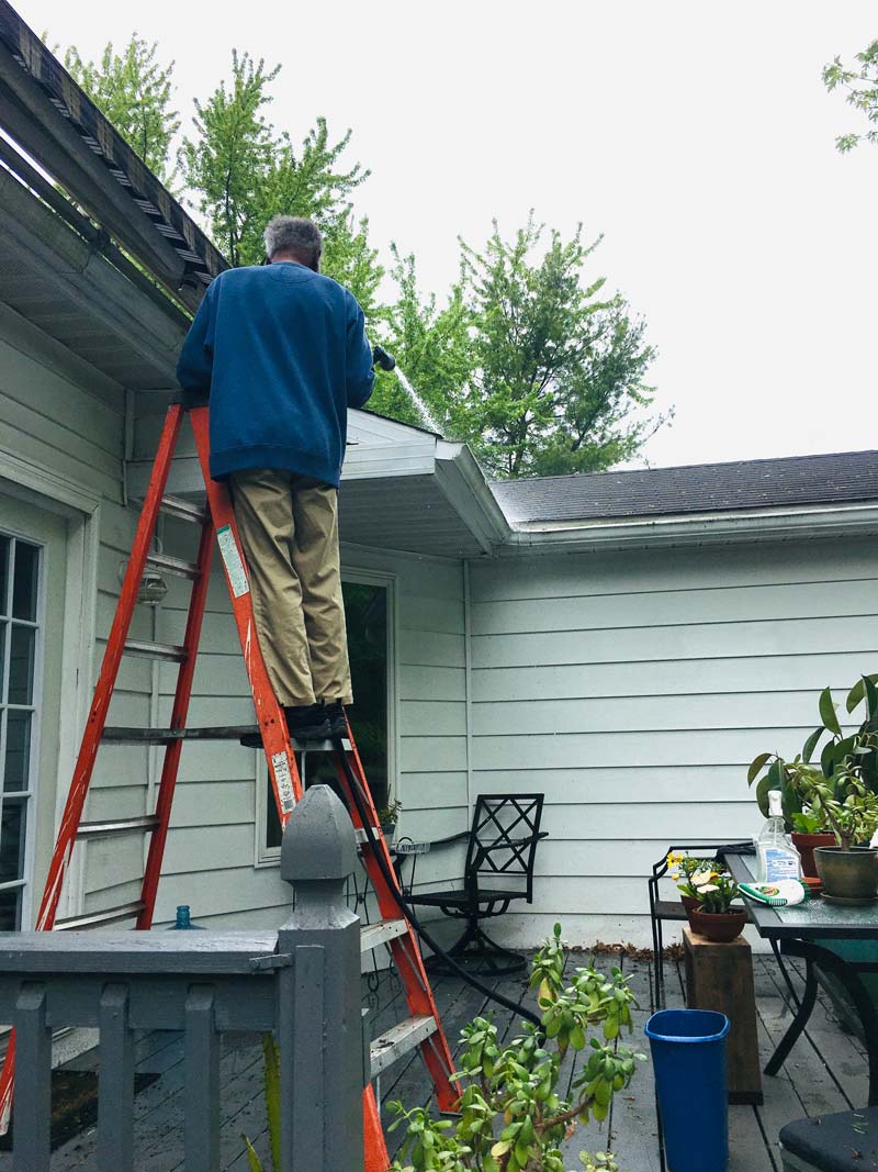 Melbournian climbing a dangerous ladder to clean their gutters