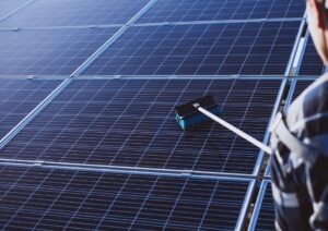 portervac worker cleaning commercial solar panel
