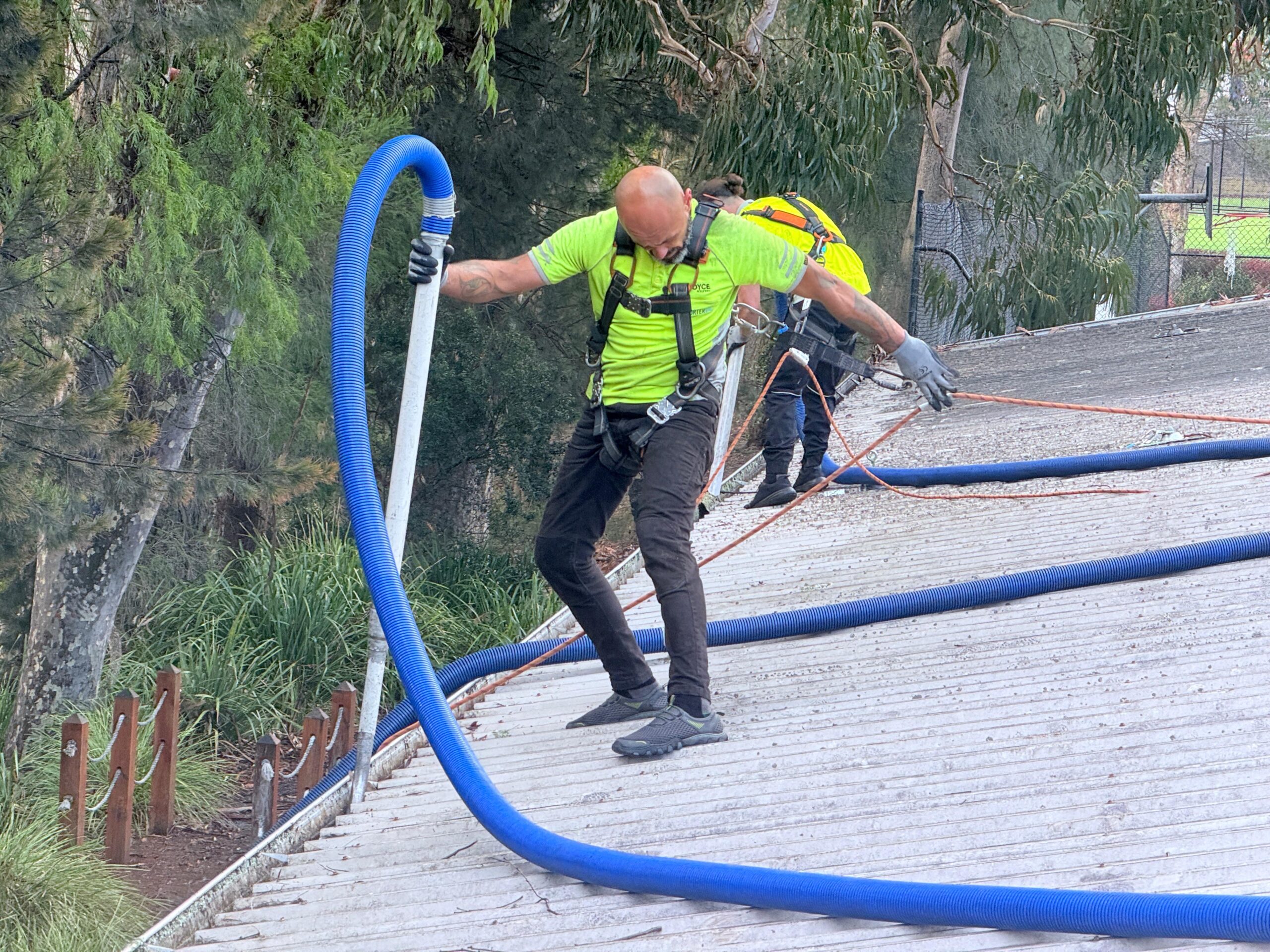 gutter cleaner on a commercial property with appropriate safety equipment