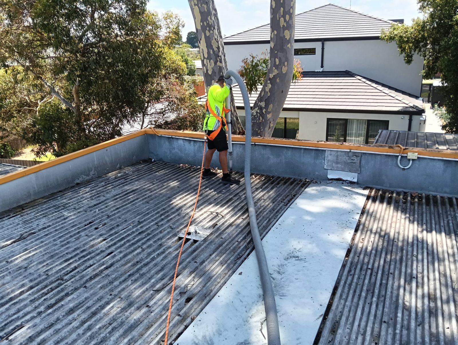 gutter cleaner wearing regulated safety equipment