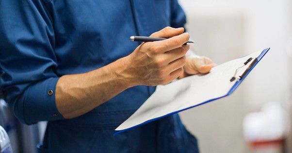 man completing an assessment of a building’s roof