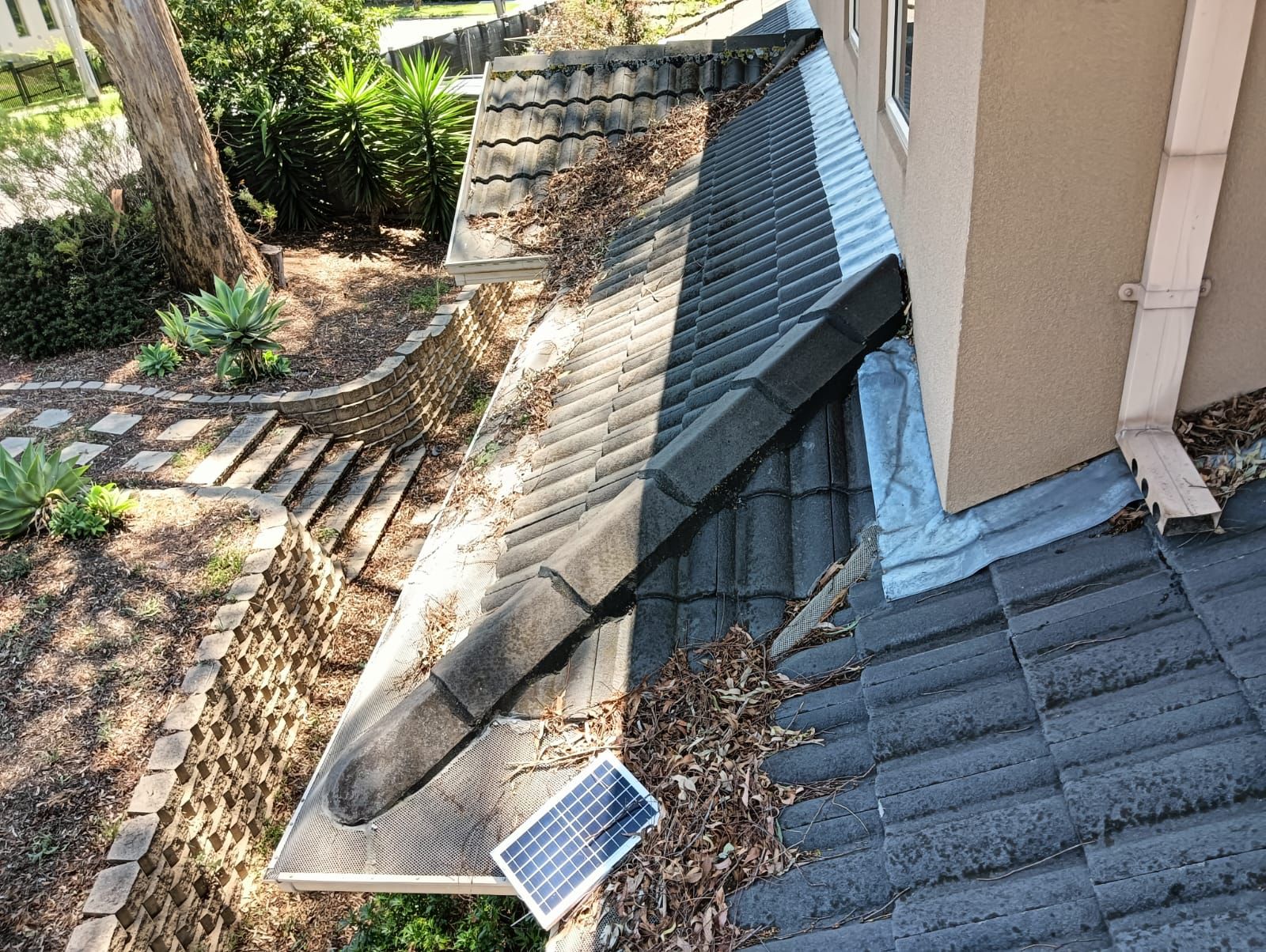 Blocked roof gutters with leaf build-up affecting gutter cleaning price in Melbourne