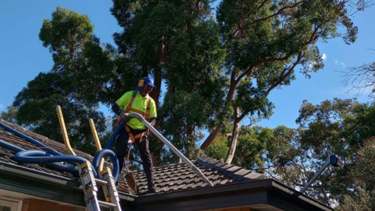 a Portervac team member clearing a Gutter in Oakleigh with a vacuum