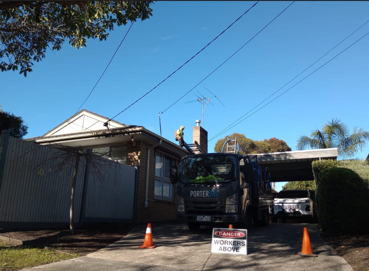Mature paperbark trees over a Heathmont home with the PorterVac truck parked in the driveway